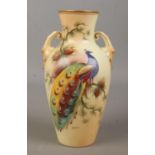 A Locke & Co Worcester hand painted vase, decorated with a peacock. Signed H Wall. 19cm.