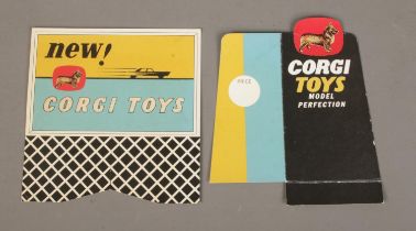 Two cardboard Corgi Toys promotional advertising signs; 'Model Perfection' and 'New! Corgi Toys'.