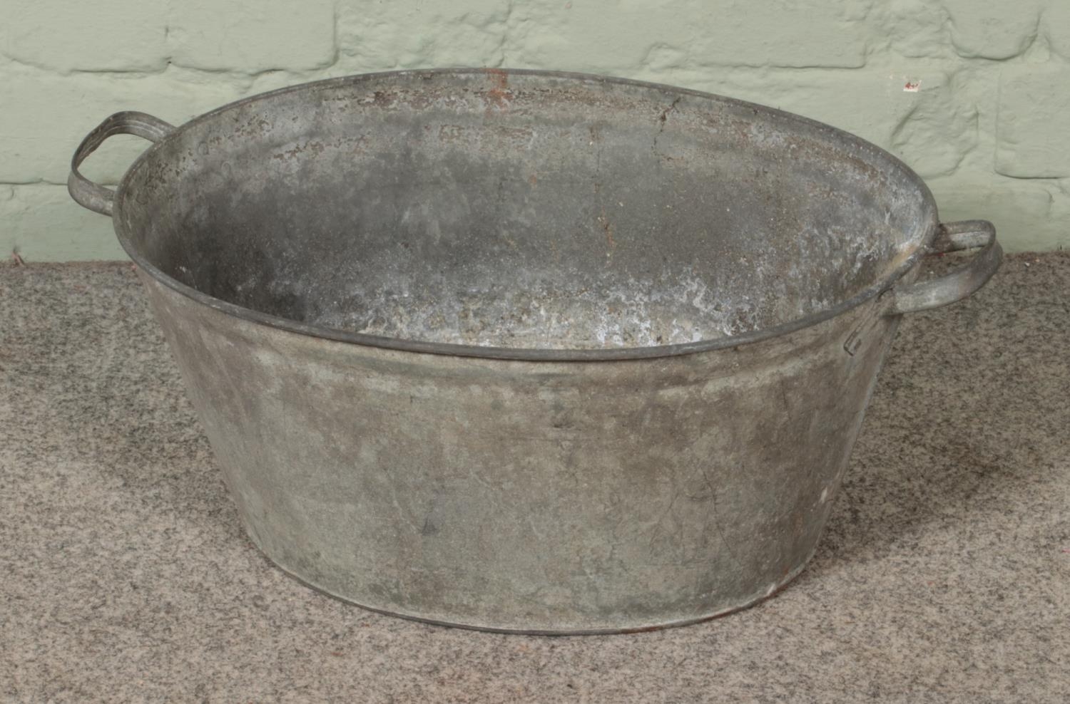 A small galvanised tin bath tub. Approx. dimensions 57cm x 41cm.