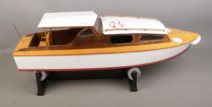 A remote control model pond cruiser on display stand featuring Planet receiver. Approx. boat