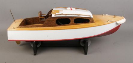 A motorised kit built model Sea Scout cabin cruiser boat on display stand. Approx. boat length 63cm.