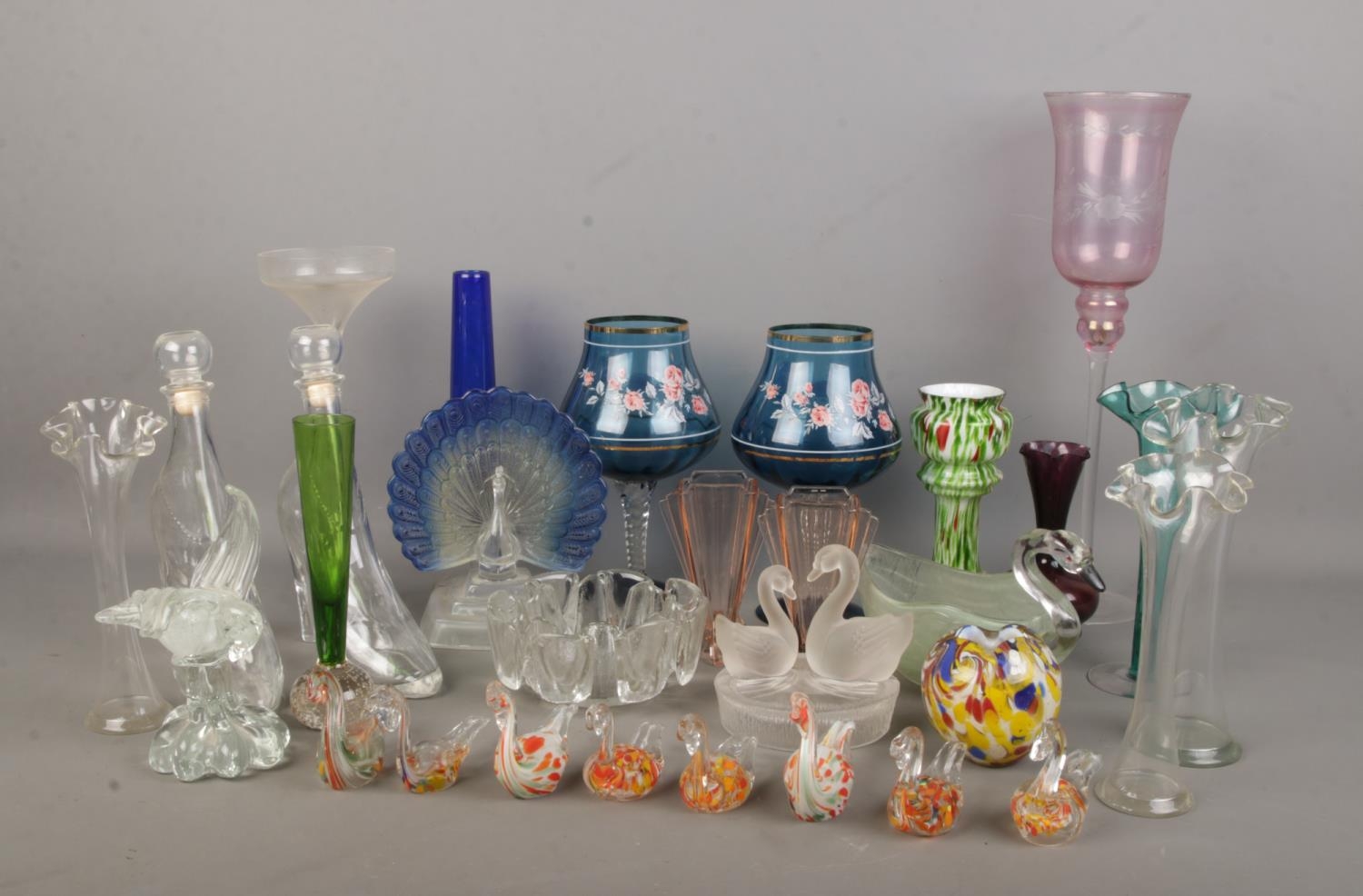 A collection of decorative glassware inlcuding shoe shaped decanters, Murano style birds, coloured