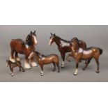 Four Beswick ceramic horses, together with a similar Royal Doulton example. Includes large Shire