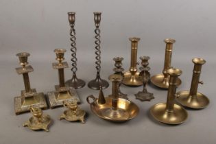 A large collection of candlesticks including peacock design, brass twist design, ejector stem