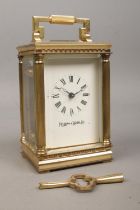 A miniature brass Mappin and Webb carriage clock, with Corinthian column supports to the corners,