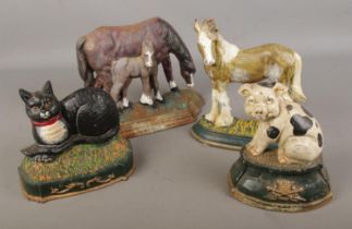 A collection of four cast iron doorstops with examples in the form of Horses, pig and cat
