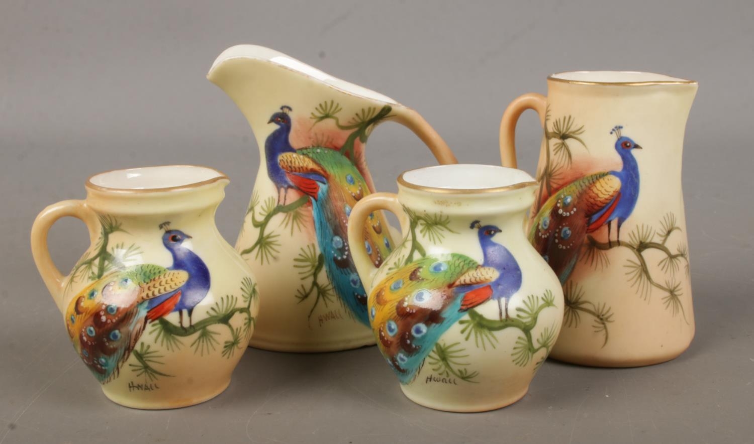 Four small Locke & Co Worcester jugs. All hand painted and decorated with a peacock. Signed H