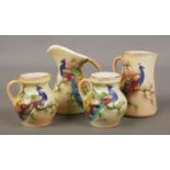 Four small Locke & Co Worcester jugs. All hand painted and decorated with a peacock. Signed H