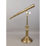 A brass four drawer desk telescope, with cogged swivel movement, mounted to a Corinthian column