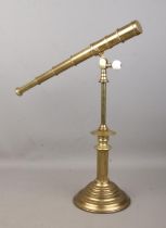 A brass four drawer desk telescope, with cogged swivel movement, mounted to a Corinthian column