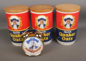 A collection of Quaker Oats collectables including three containers and an alarm clock