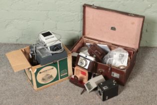 A boxed Rank Hylite Firefly slide projector with a selection of vintage cameras and accessories