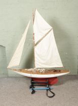 A very large remote control model pond yacht titled Moonbeam on display stand modelled after an