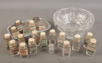 A cut glass bowl and tray with contents of reproduction acid/poison bottles.