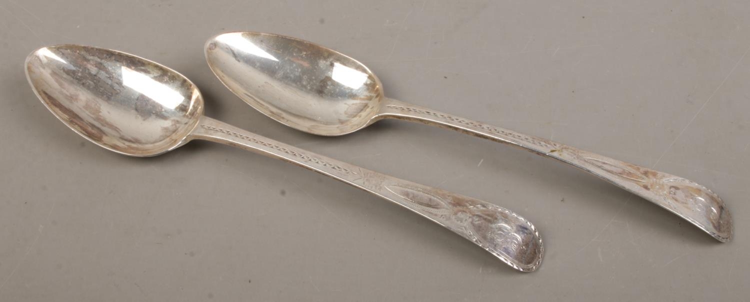 A pair of late Eighteenth Century Georgian table spoons, with floral detailing and 'E' engraved to