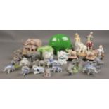 A large collection of various elephant figures including large green elephant piggy bank, small blue