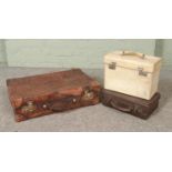 A vintage leather suitcase along with two other cases.