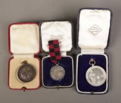 Three cased medals to include silver Junior School Sports, Royal Life Saving Society and The