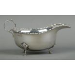 An Edwardian silver sauceboat, with beaded rim raised on three hoofed feet. Assayed for