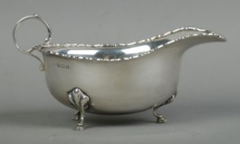 An Edwardian silver sauceboat, with beaded rim raised on three hoofed feet. Assayed for