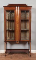 An Edwardian inlaid mahogany display cabinet. With two doors and raised on tapering supports with