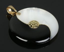 A 14ct gold, mother of pearl and onyx Yin Yang pendant. Having central Hanzi characters. Diameter