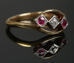 An 18ct gold and platinum, diamond and ruby three stone ring. Makers mark for AW Crosbee & Sons Ltd.
