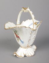 A Rockingham helmet shaped basket with arched handle. With hand painted exotic birds in the manner