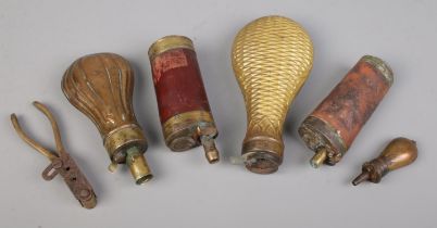 A collection of antique powder flasks and a brass bullet mould. Includes two three way powder