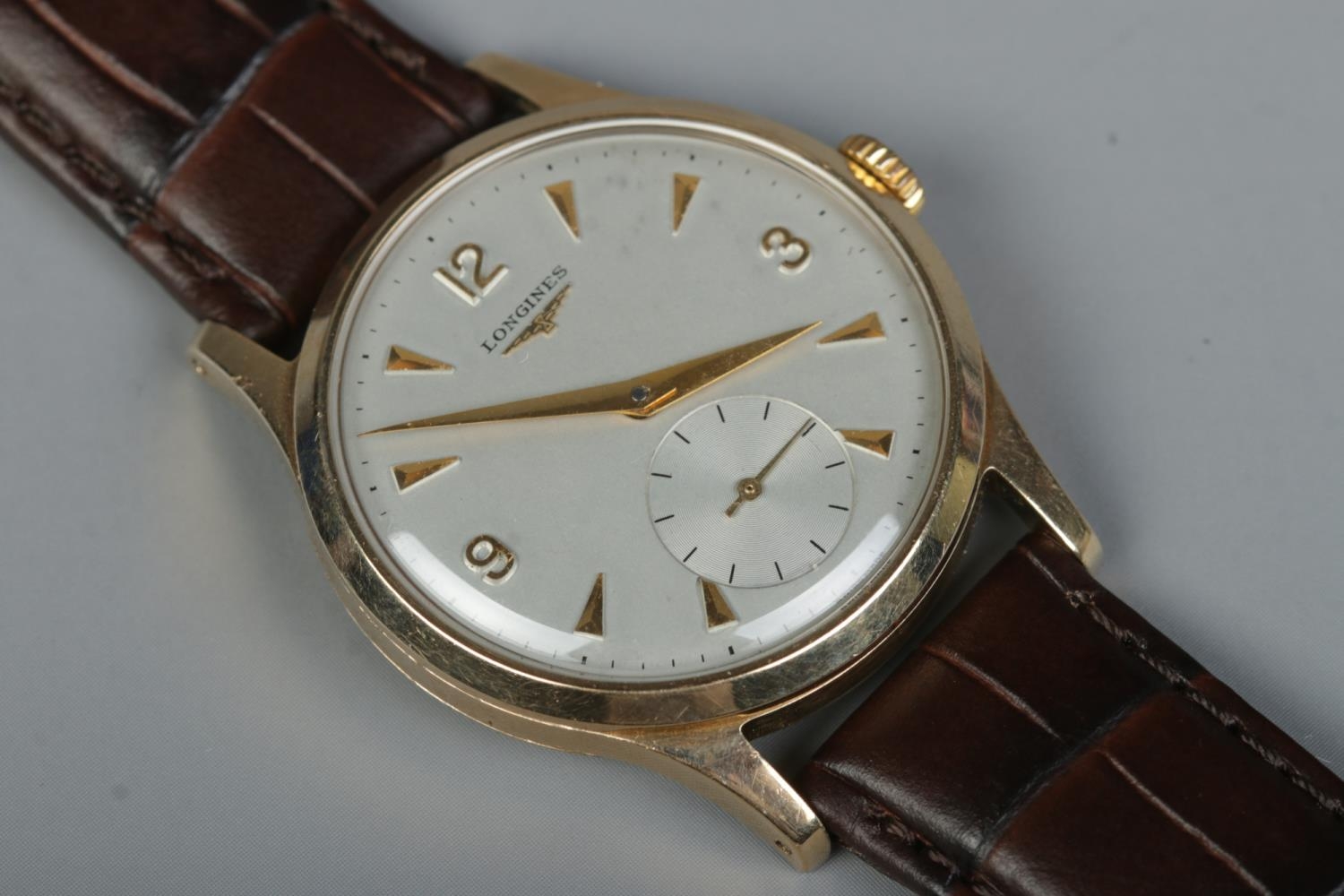 A gents 9ct gold Longines manual wristwatch. Having subsidiary seconds and baton and Arabic