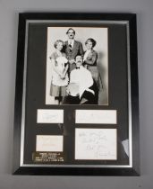 A framed set of Faulty Towers signatures mounted below monochrome photograph of cast. Includes