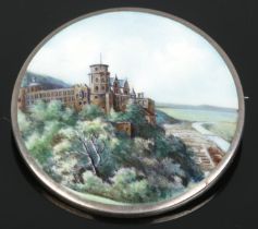 A continental silver and enamel brooch decorated with a landscape scene and castle. Stamped 800 to