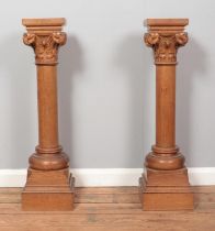 A pair of carved oak columns raised on stepped bases. Having scrolled acanthus leaf decoration.