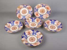 A collection of early 19th century Crown Derby porcelain plates/bowls decorated in an imari pattern.