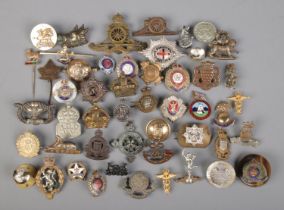 A collection of mainly military pin badges, buttons and stick pins.