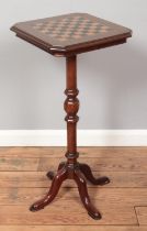A Victorian inlaid mahogany games table raised on centre column and four supports. Height 80cm.