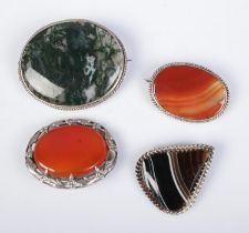 Four agate set silver mounted brooches. One example stamped, all others test as silver.