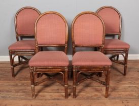 A set of four bamboo dining chairs with upholstered seat and back.