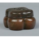 A Chinese bronze hand warmer of lobed form, having pierced cover. Character marks to base. 4cm x 6.