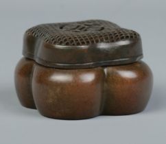 A Chinese bronze hand warmer of lobed form, having pierced cover. Character marks to base. 4cm x 6.