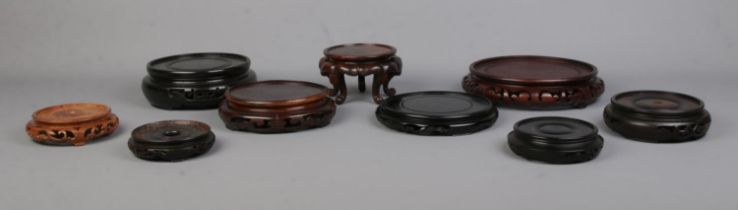 Nine Chinese carved hardwood stands of various sizes. Largest 18.5cm, Smallest 8.5cm.