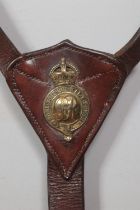 A World War One leather cavalry breastplate with brass George V badge and Latin motto Honi soit