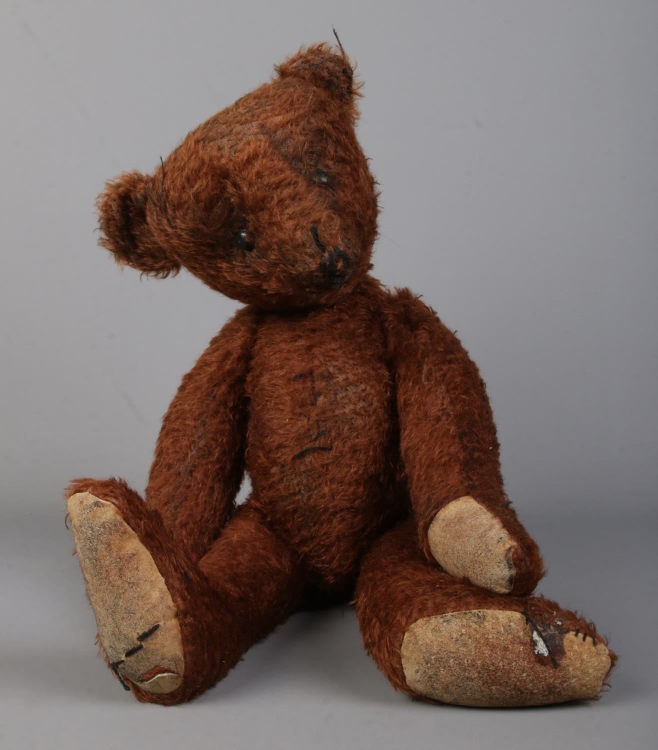 A vintage jointed teddy bear. Sat height: 28cm.