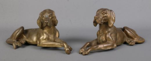 A pair of bronze sculptures modelled as recumbent dogs. Length 27cm.