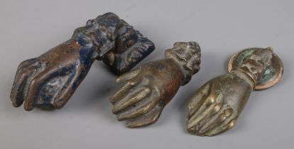 Three novelty cast metal door knockers, formed as hands.