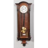 A 19th century walnut Vienna twin weight wall clock. Having enamel dial and Roman numeral markers.