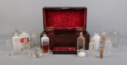 An early 19th century mahogany apothecary box with contents of glass medicine and poison bottles.