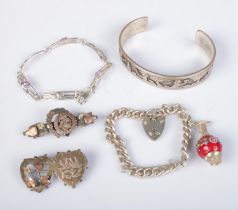 A collection of silver jewellery to include bangle engraved with village scene, charm bracelet,