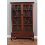 An Edwardian mahogany astragal glazed display cabinet with Greek key moulding and two drawer base.
