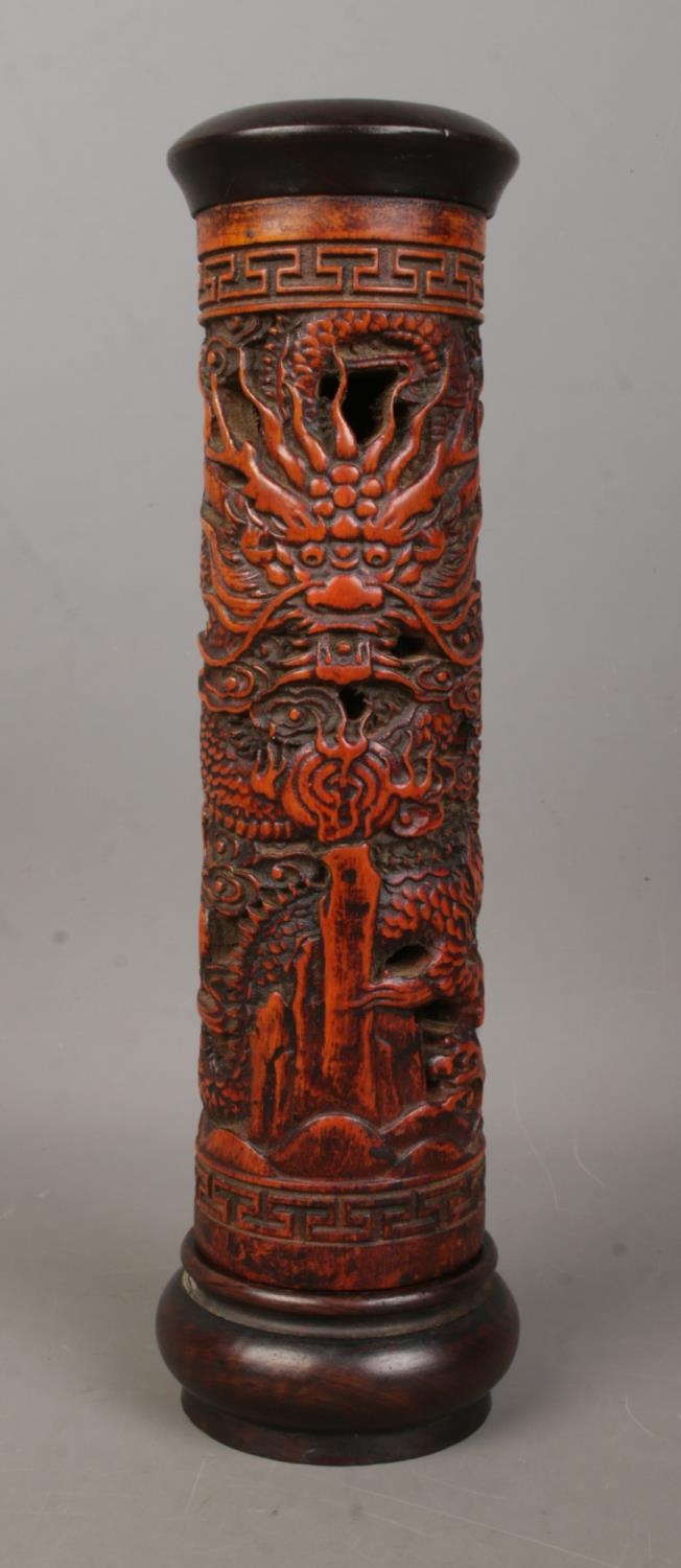 A Chinese wooden incense holder with carved decoration depicting dragons. Height 25cm.